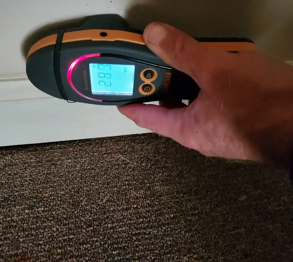 Moisture detection at baseboard during Storm Damage Restoration in Alice